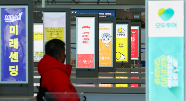지난  7일 인천국제공항 제2여객터미널을 찾은 탑승객이 여행사 카운터 부스를 지나고 있다. 연합뉴스